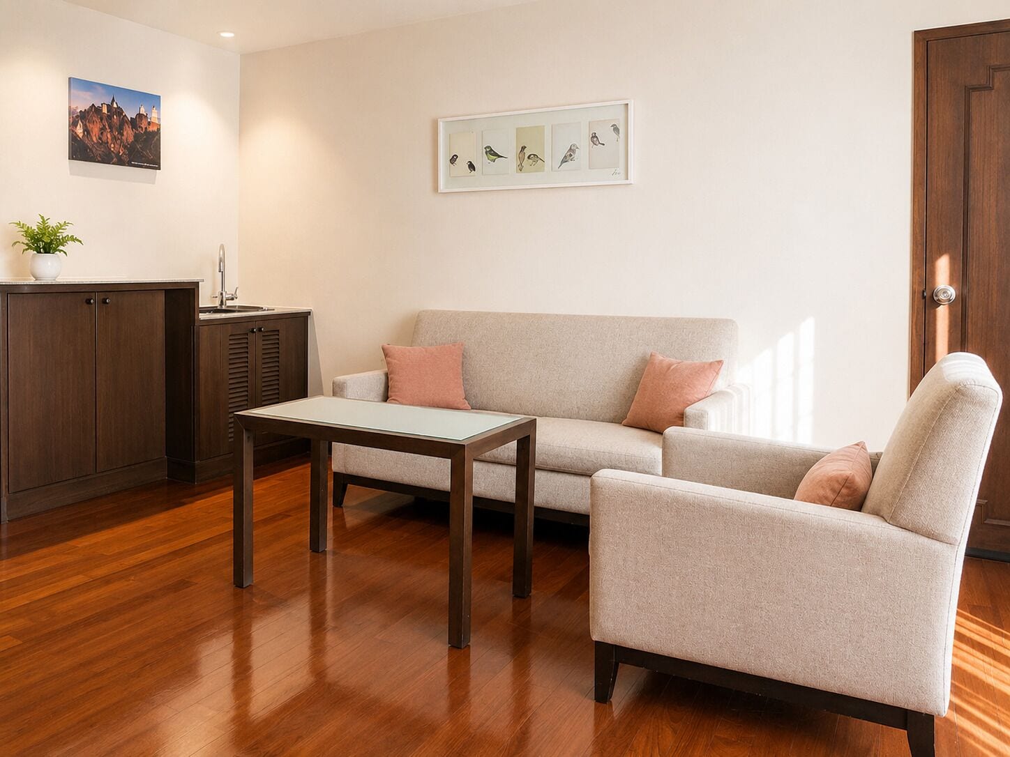 Ein Wohnzimmer mit Sofa, Sessel, Couchtisch und Schrank.
