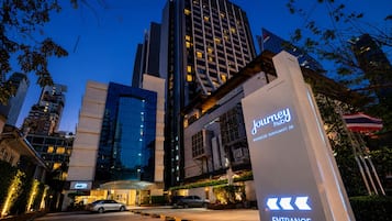A hotel entrance with a modern design, including a prominent sign and directional arrows.