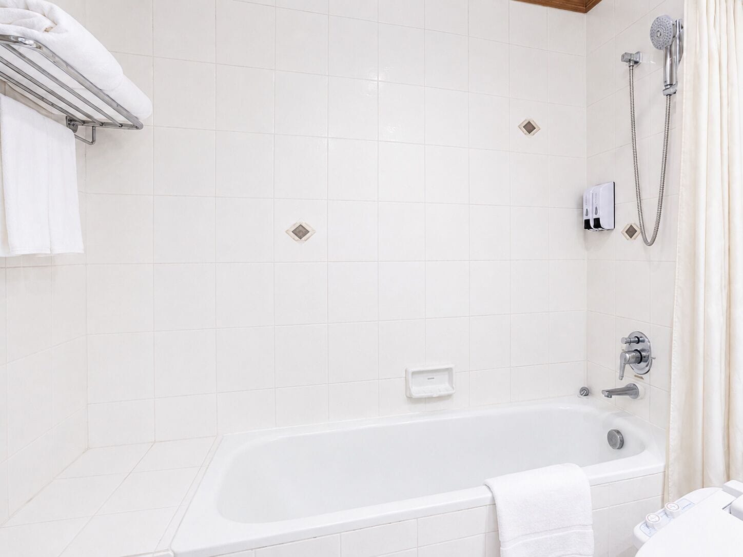 A modern bathroom with a bathtub, a shower, and a towel rack.