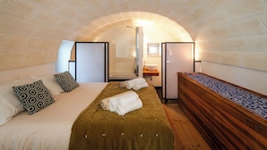 A cozy bedroom with a bed, a wooden dresser, and a small window.