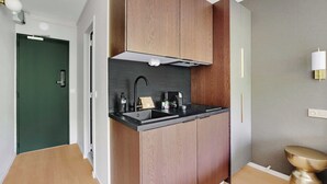 Eine moderne Küche mit Holzausbau, einer schwarzen Arbeitsplatte und einem Edelstahl-Spülbecken.
