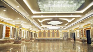 A spacious lobby with a polished marble floor, ornate columns, and a large chandelier. - TreeHouse The Royal Chandra Mahal (Jaipur)