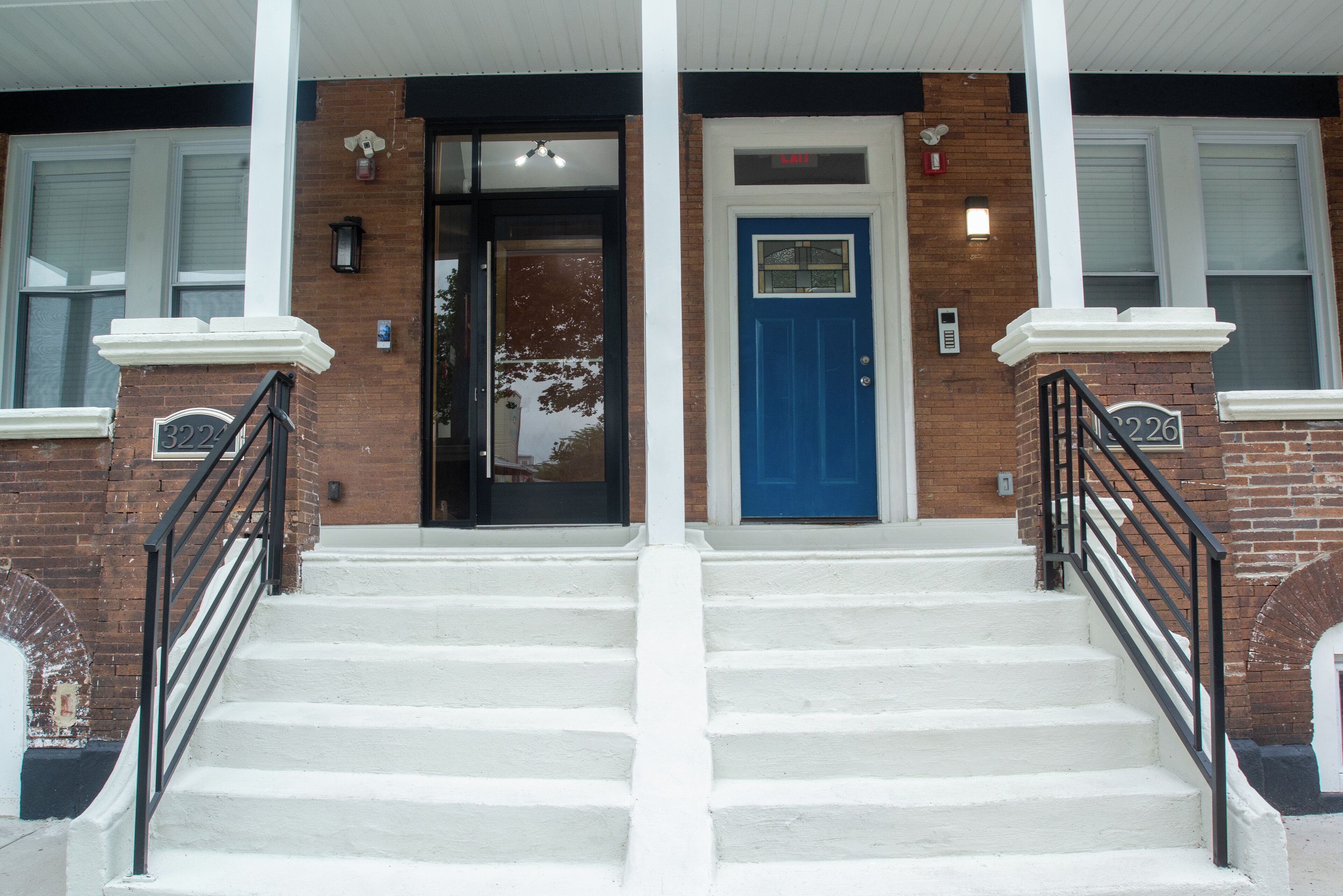 A building with a blue door, white steps, and black railings.