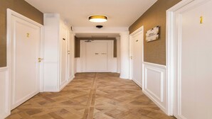A hallway with white doors numbered 1 to 3, a ceiling light, and a welcome sign on the wall. - Charming private room in Pigalle (Paris)