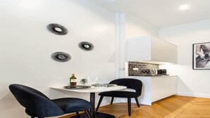 A modern kitchen with a white countertop, black chairs, and a dining table. - Elegant studio - 2P - TrocadÃ©ro / Eiffel Tower (Paris)