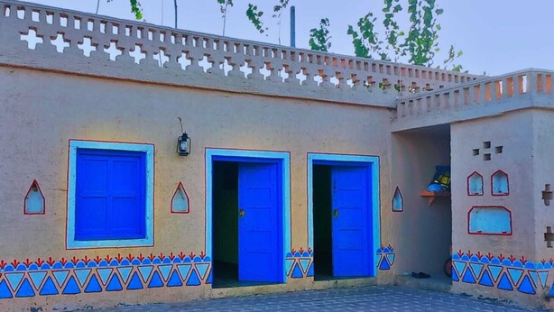 A building with three blue doors and a decorative border. - oshiana farm (Pehowa)