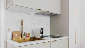 A modern kitchen with a stainless steel sink, white cabinets, and a tiled backsplash. - Modern "Green Suites" residence - Meudon/Vélizy (Meudon)