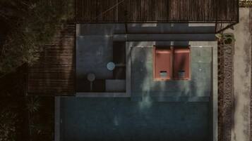 A modern house with a flat roof, a small patio area, and a large open space.