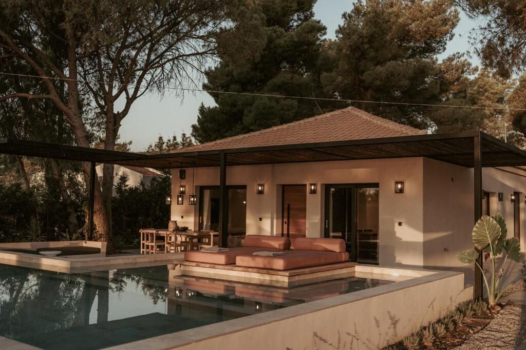 A modern house with a swimming pool, outdoor seating, and a patio.