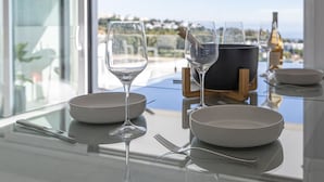A dining table with wine glasses, plates, and cutlery, overlooking a scenic view.