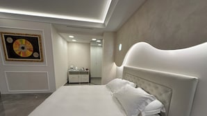 Una camera da letto moderna con un letto grande, un comodino, un armadio e uno specchio.