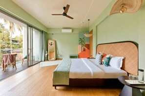 A bedroom with a bed, a ceiling fan, a large window, and a view of the outdoors.
