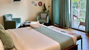 Un dormitorio con cama, dos sillas, escritorio y aire acondicionado, con vistas al exterior.