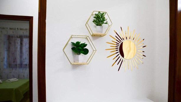 A hallway with a white wall, a wooden door frame, and a white shelf.