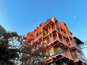 Un immeuble à plusieurs étages doté de balcons, avec un ciel d égagé.