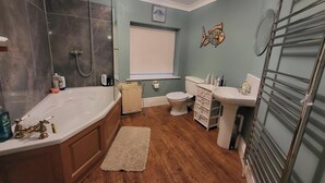 A bathroom with a bathtub, toilet, and sink. - Three Farthings Bed & Breakfast, a quiet and peaceful countryside location. (Driffield)