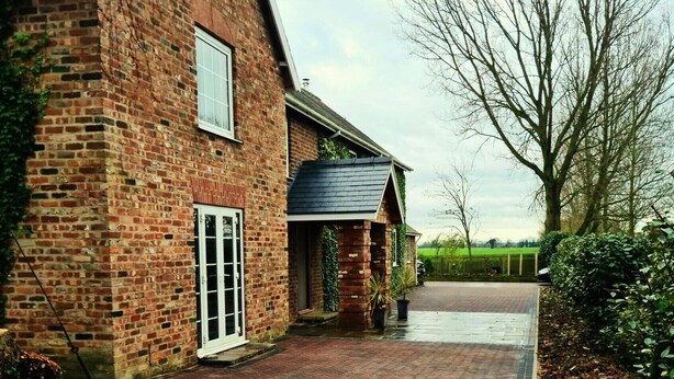 A brick house with a paved driveway leading to a garage. - Three Farthings Bed & Breakfast, a quiet and peaceful countryside location. (Driffield)