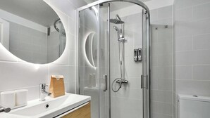 A modern bathroom with a glass-enclosed shower, a sink with a mirror, and a toilet. - Modern "Green Suites" residence - Meudon/Vélizy (Meudon)