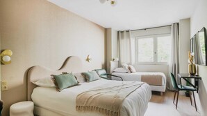A hotel room with a large bed, a smaller bed, a desk with a chair, and a window with curtains. - Modern "Green Suites" residence - Meudon/Vélizy (Meudon)