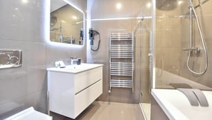 A modern bathroom with a glass-enclosed shower, a white vanity with a mirror, and a towel rack. - Magnificent studio - 2P - near the Palais Garnier (Paris)