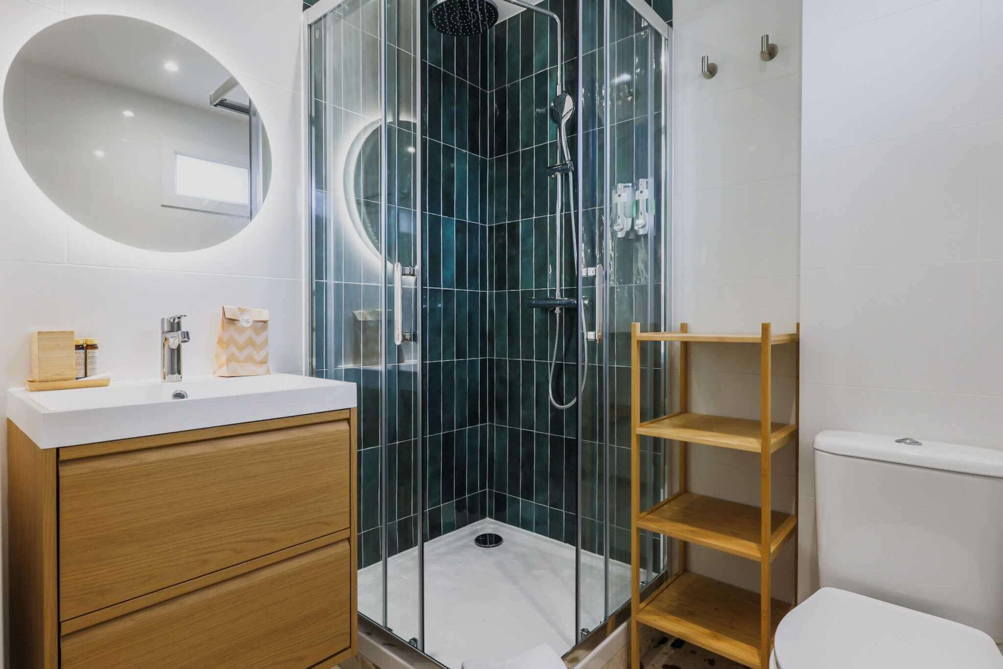 A modern bathroom with a glass-enclosed shower, a wooden vanity, and a white toilet.