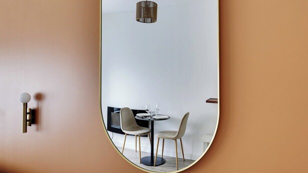A modern dining area with a round table, two chairs, and a hanging light fixture. - Magnificent studio - 2P - Near Bastille (Paris)