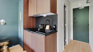 Une cuisine moderne avec des meubles en bois, un plan de travail noir et une cuisinière intégrée.
