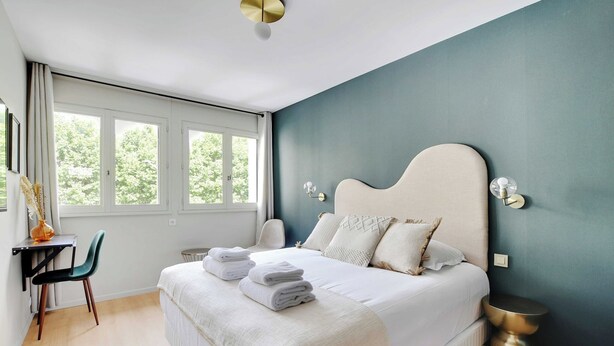 Une chambre à coucher avec un grand lit, un bureau et une chaise.