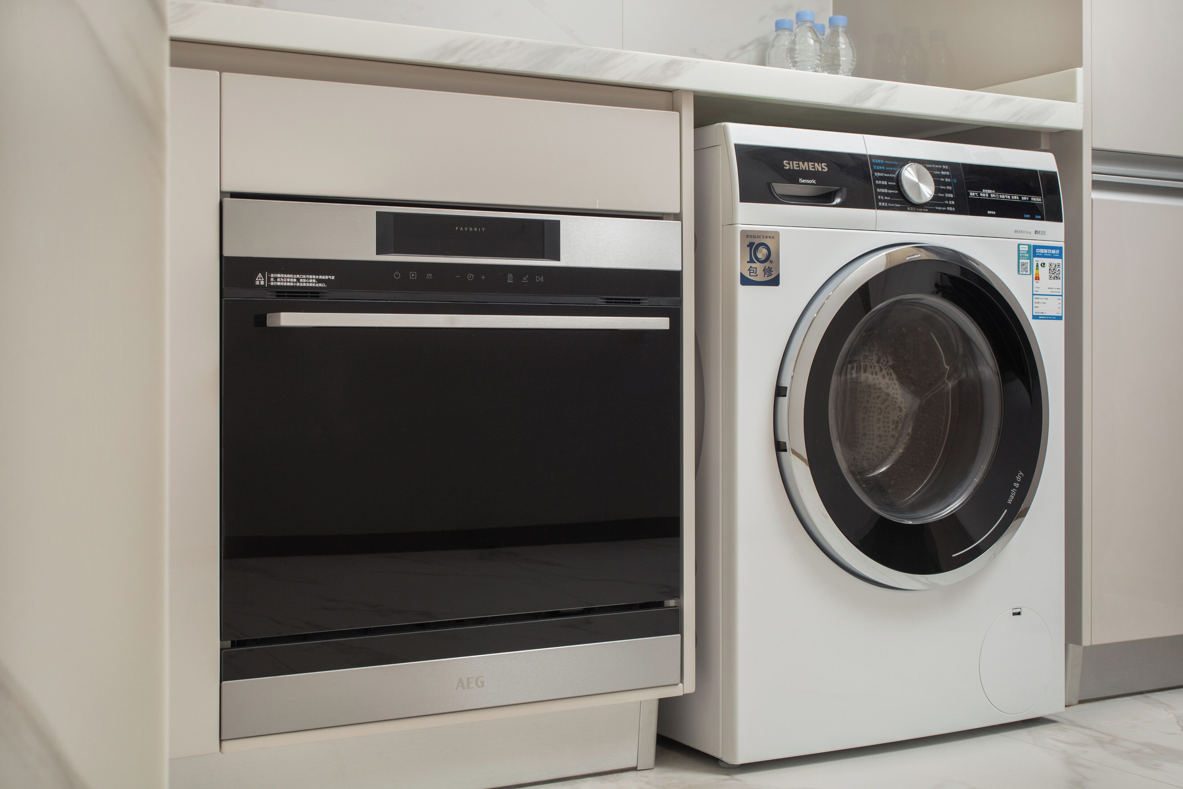 A compact washer and dryer unit in a modern kitchen setting.