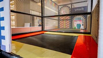 Ein Indoor-Spielbereich mit gepolstertem Boden und Sicherheitsnetzen.