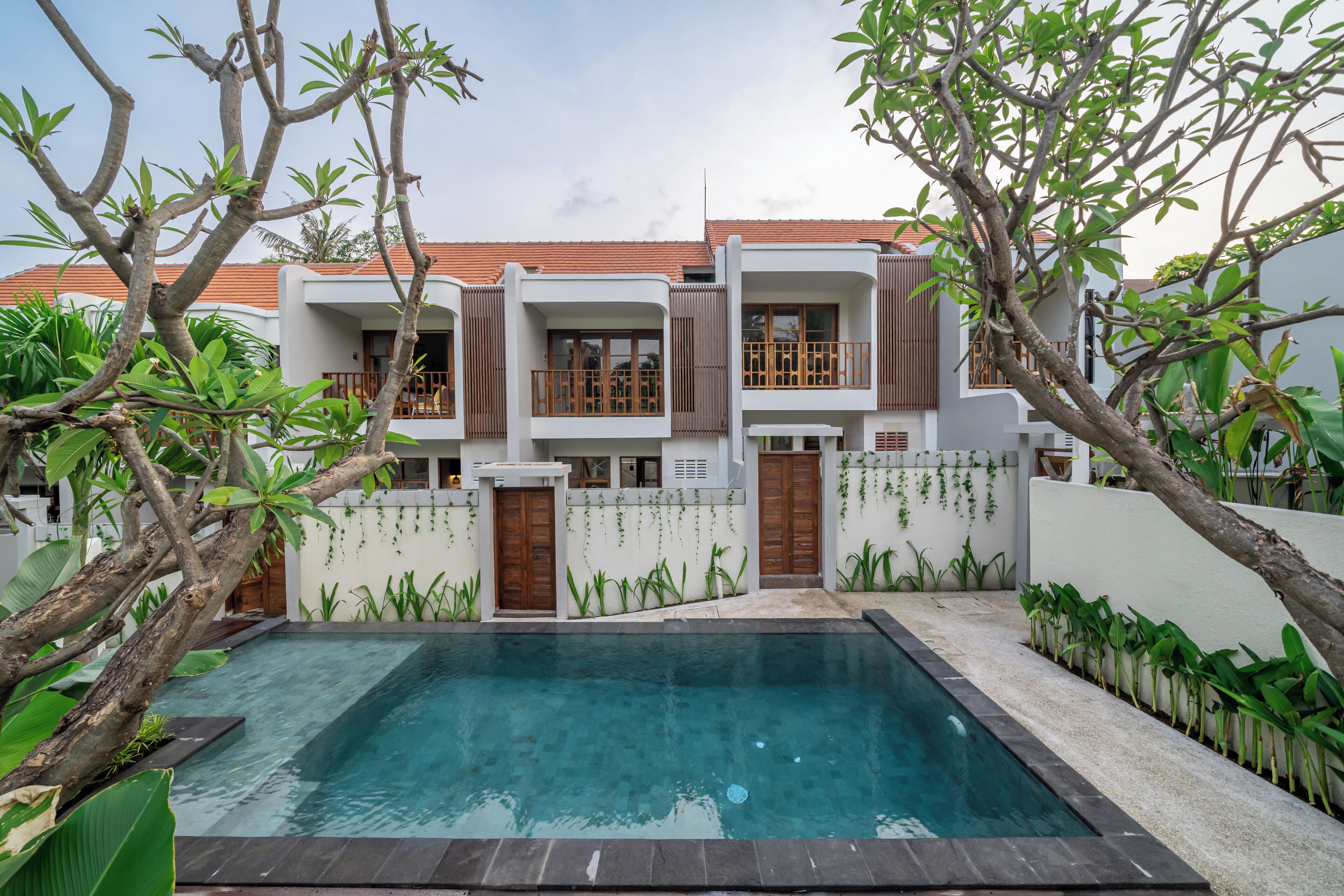 Una casa moderna de dos pisos con una piscina al frente.