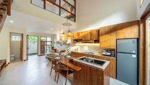 A modern kitchen with wooden cabinets, a built-in island, and a GE refrigerator. - Chindaga Villa Canggu (Canggu)