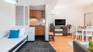 Espaço compacto com cozinha compacta, área de refeições e cama.
