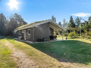 A modern, single-story building with a flat roof and a covered patio area.