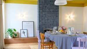 A dining area with a checkered tablecloth, wooden chairs, and a tiled backsplash.