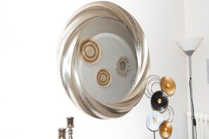 A metallic tray with decorative elements, a white radiator, and a floor lamp.