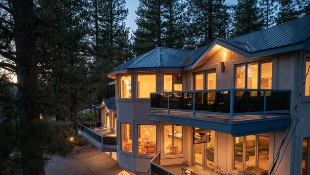 A modern multi-story house with large windows, a balcony, and a patio area. - 90s Tahoe Time Capsule (Incline Village)