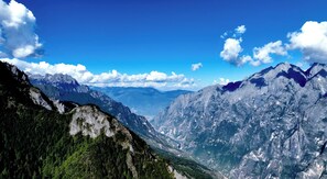A mountainous landscape with a valley and distant peaks under a clear sky. - Shangri-La ManXinYu Frozen Dream Forest (Deqin)