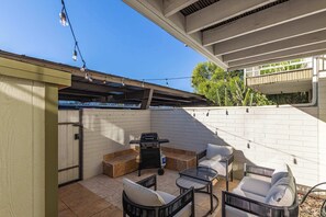 An outdoor patio with a grill, seating area, and string lights. - NEW|Heatherbrae 8|Old Town|Htd. Pool|Mtn View (Scottsdale)