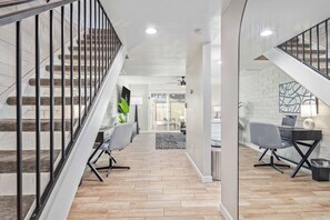 Ein modernes Interieur mit Treppe, Bürostühlen, Schreibtisch und Laptop.