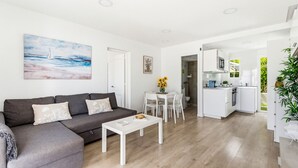A modern living room with a grey sofa, a white coffee table, and a painting of a sailboat. - Castellsol 315 (Arenal d´en Castell)