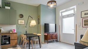 Un espace de vie compact comprenant un coin repas, une kitchenette et un téléviseur.