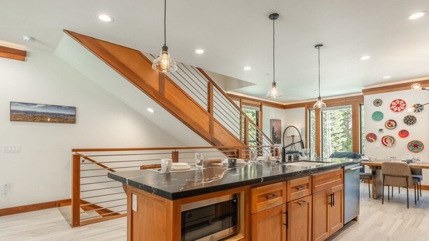 A modern kitchen with a wooden island, stainless steel appliances, and a staircase leading to another level. - Private Hot Tub | Near Eagle Lodge (Mammoth Lakes)