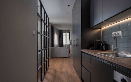 A modern kitchen with a built-in oven, a sink, and a coffee maker.