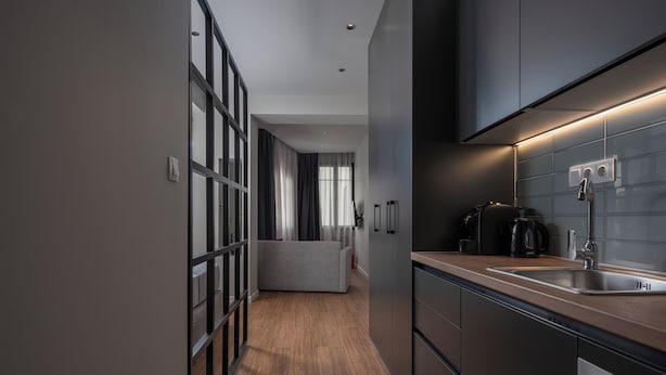 A modern kitchen with a built-in oven, a sink, and a coffee maker. - Hebrard Industrial Suites (Thessaloniki)