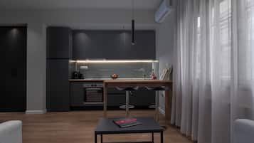 A modern kitchen with dark cabinetry, a central island, and pendant lighting.