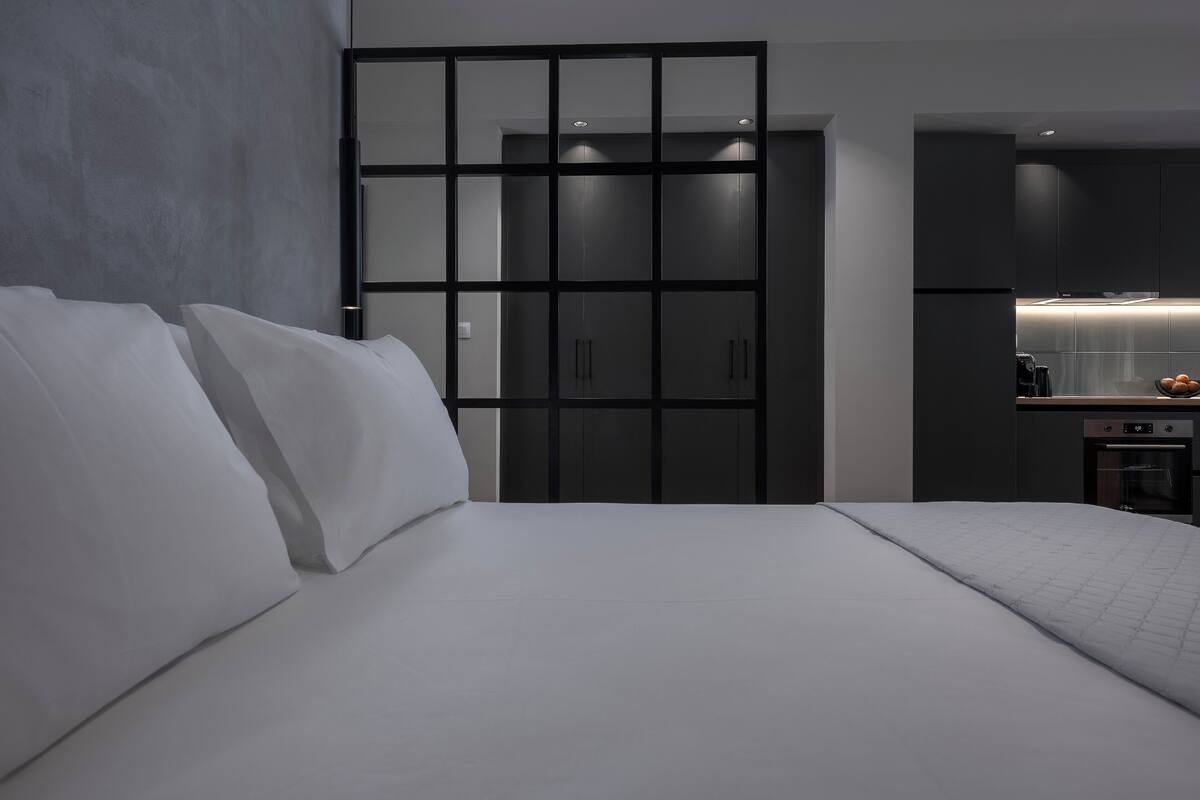 Ein modernes Schlafzimmer mit einem großen Bett, einem Kleiderschrank und einer Küchenzeile.