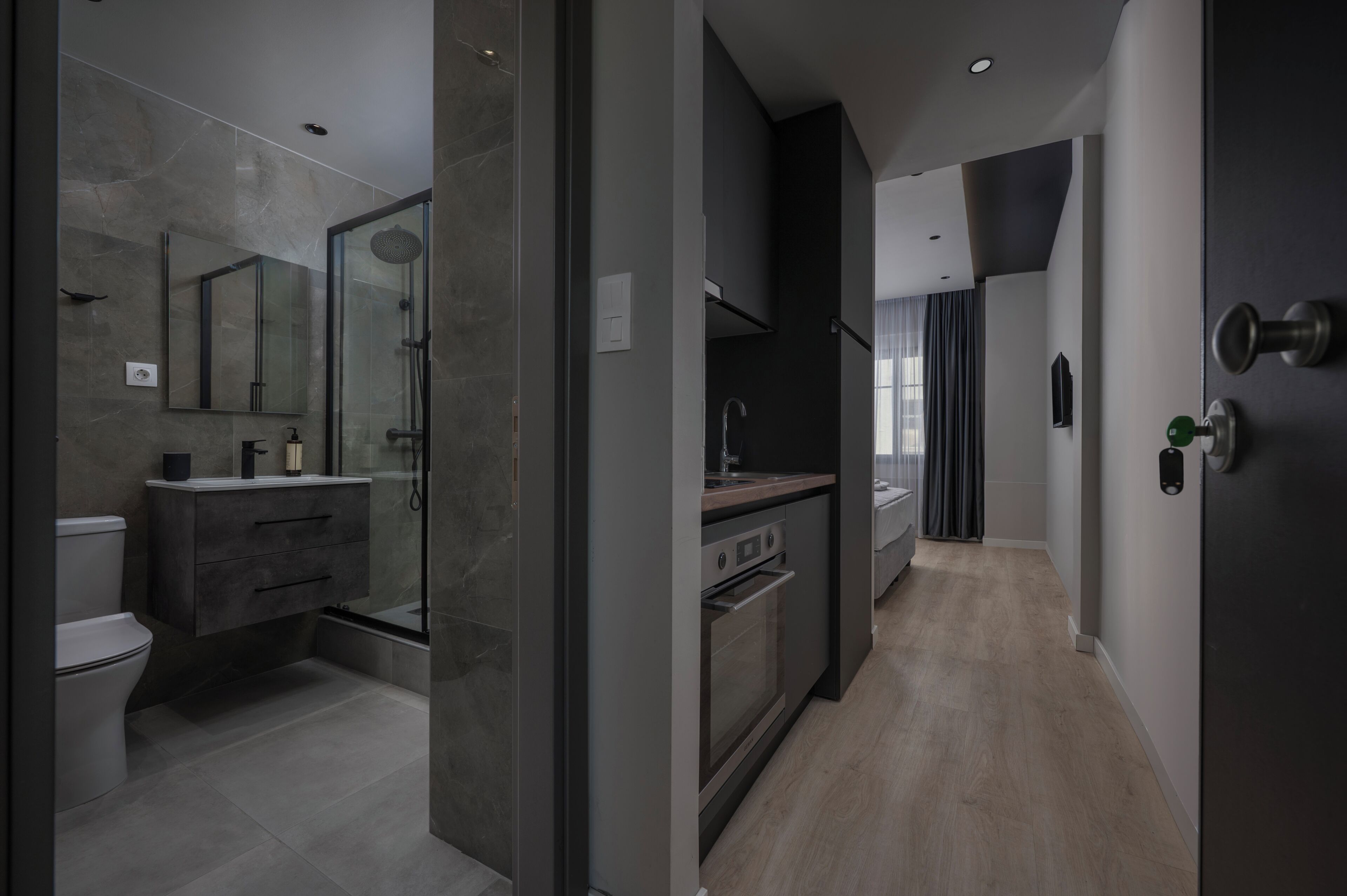 A modern bathroom with a glass-enclosed shower, a toilet, and a vanity with a mirror.