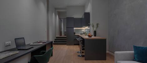 A modern, compact living space with a kitchenette, a dining area, and a seating area.
