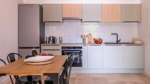 A modern kitchen with white cabinets, a wooden countertop, and a built-in oven.
